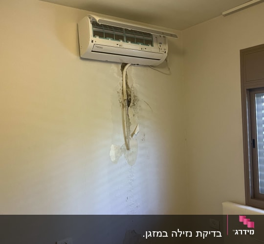 מזגן מותקן על קיר עם סימני רטיבות